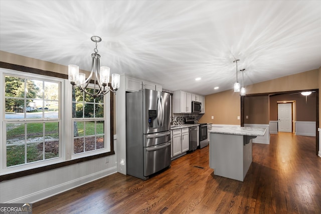 kitchen featuring a kitchen breakfast bar, pendant lighting, stainless steel appliances, a center island, and dark hardwood / wood-style floors