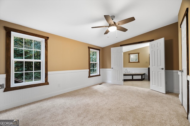 interior space with lofted ceiling, light colored carpet, and plenty of natural light