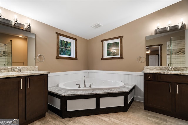 bathroom with vaulted ceiling, hardwood / wood-style floors, independent shower and bath, and vanity