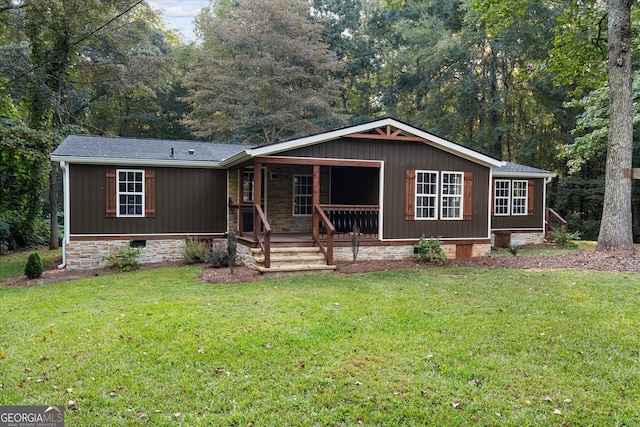 manufactured / mobile home featuring a front lawn and covered porch