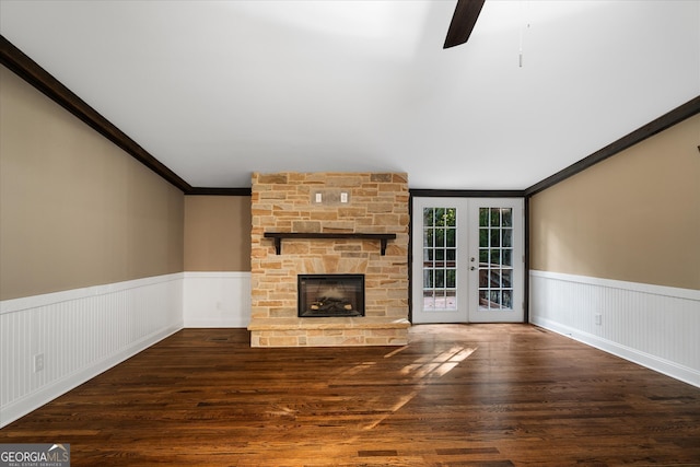 unfurnished living room with ceiling fan, ornamental molding, french doors, a fireplace, and dark hardwood / wood-style flooring