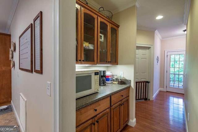 kitchen featuring wood-type flooring and crown molding