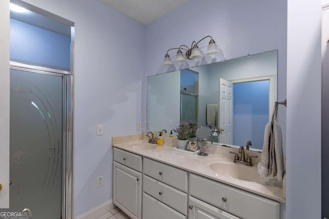 bathroom with walk in shower, vanity, and tile patterned floors