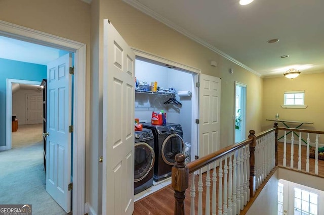 corridor featuring crown molding, independent washer and dryer, and light colored carpet