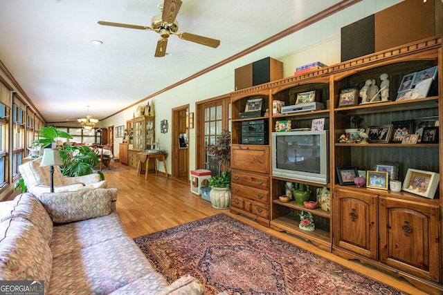 living room with ceiling fan with notable chandelier, crown molding, and wood-type flooring