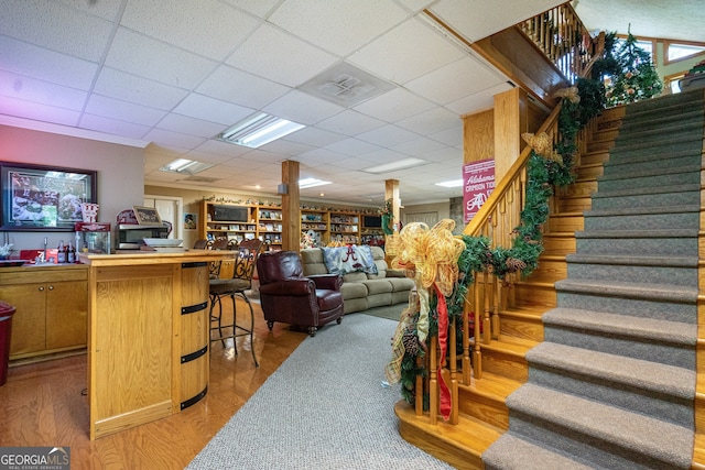 interior space featuring bar area, a drop ceiling, and hardwood / wood-style floors