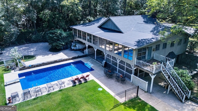 view of swimming pool with a lawn, a patio area, and a diving board