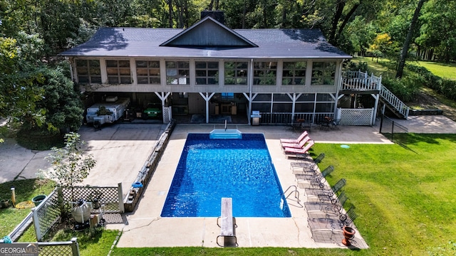 rear view of property with a fenced in pool, a sunroom, a lawn, and a patio