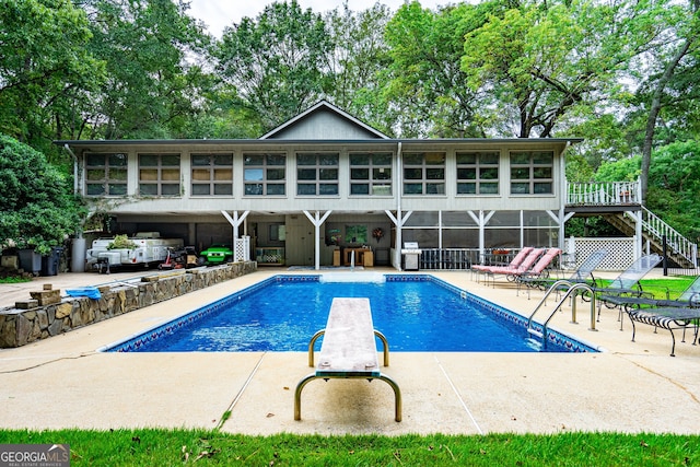 view of swimming pool with a patio and a diving board