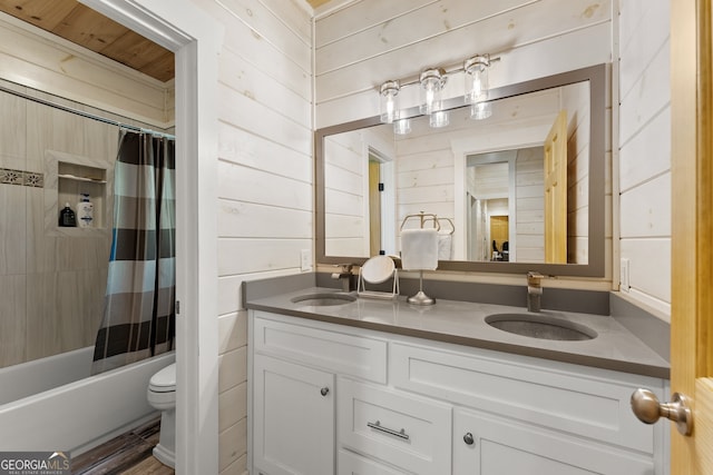 full bathroom featuring shower / bath combo with shower curtain, wood walls, toilet, and vanity