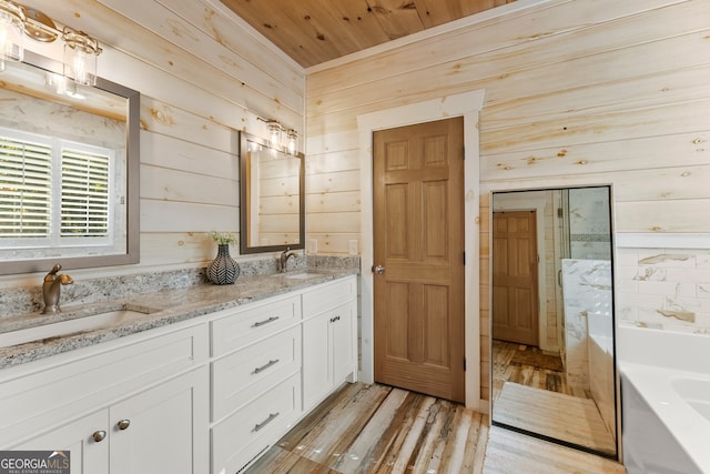 bathroom with wood walls, a tub, vanity, and hardwood / wood-style flooring