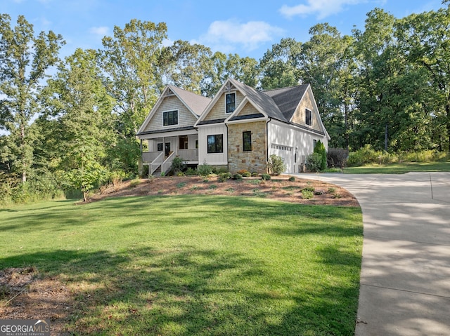 view of front of property with a garage, covered porch, and a front yard