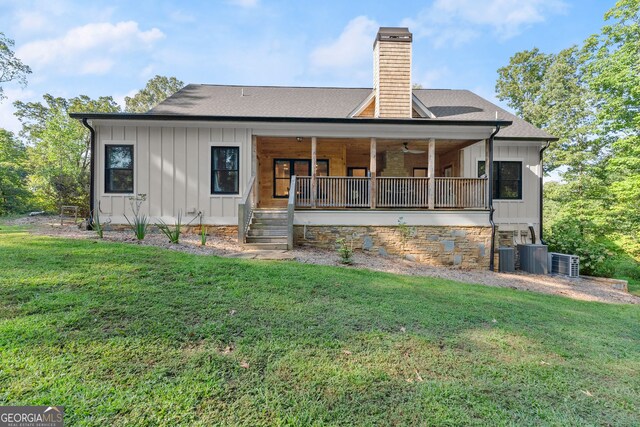 back of property featuring central AC and a yard