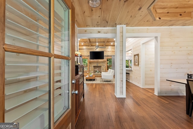 entryway with hardwood / wood-style flooring, a fireplace, wood walls, and wooden ceiling