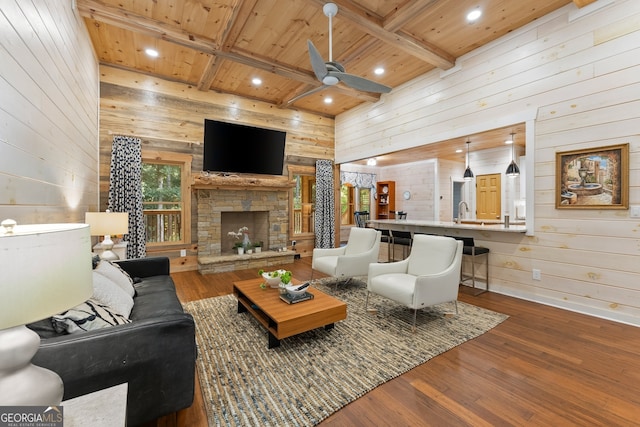 living room featuring beamed ceiling, wooden ceiling, ceiling fan, wooden walls, and hardwood / wood-style floors