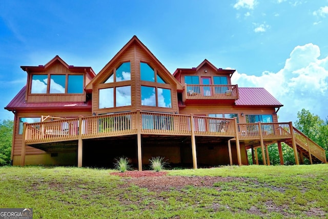 rear view of house featuring a lawn and a wooden deck