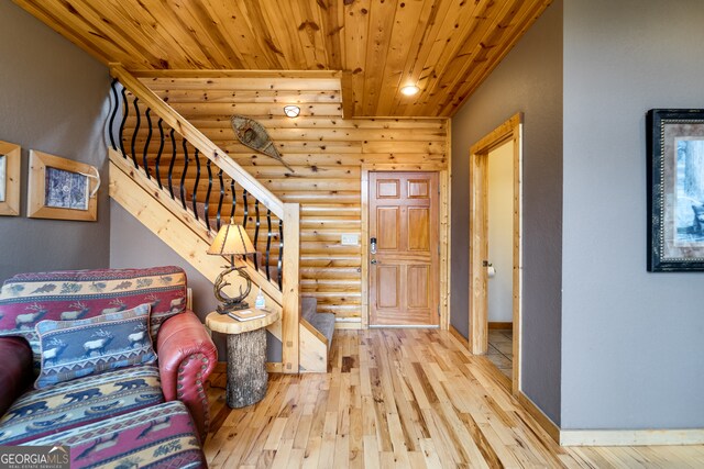 entryway featuring light wood-type flooring, rustic walls, and wooden ceiling