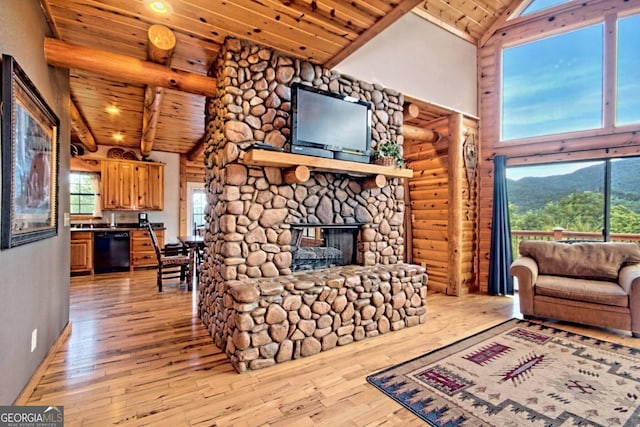 living room with log walls, high vaulted ceiling, a fireplace, light wood-type flooring, and wooden ceiling