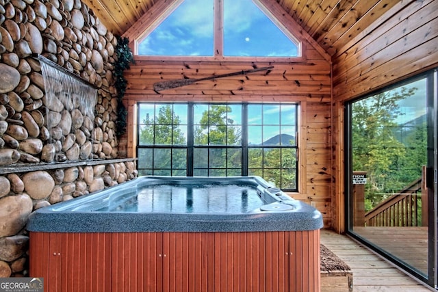 unfurnished sunroom featuring wooden ceiling, vaulted ceiling, a hot tub, and plenty of natural light