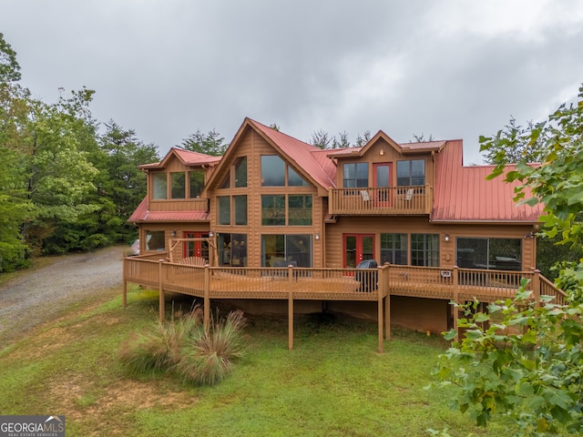 back of house featuring a balcony and a yard