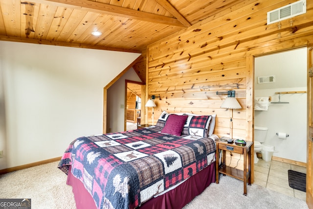 bedroom with connected bathroom, vaulted ceiling with beams, light colored carpet, and wooden ceiling