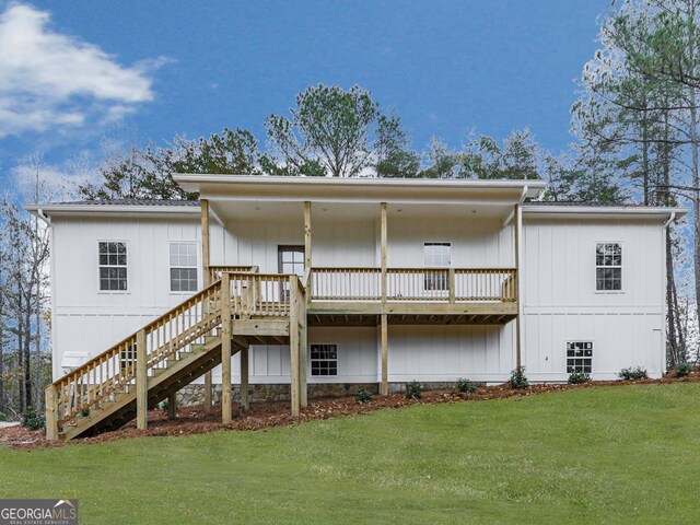 rear view of house featuring a yard and a deck