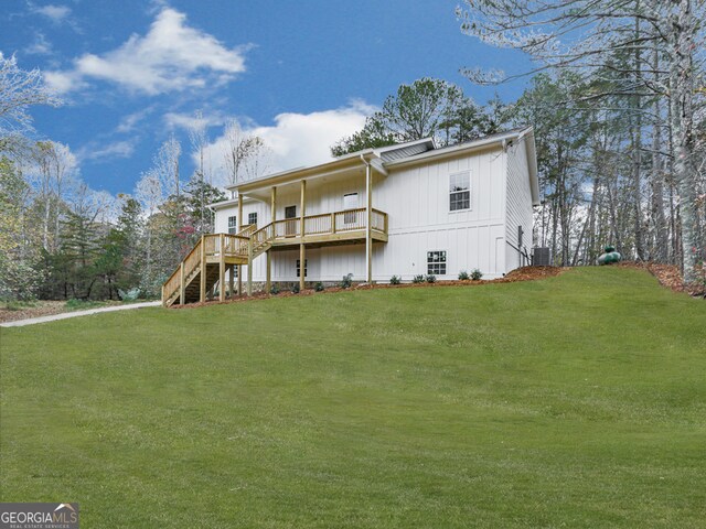 back of property featuring central air condition unit and a lawn