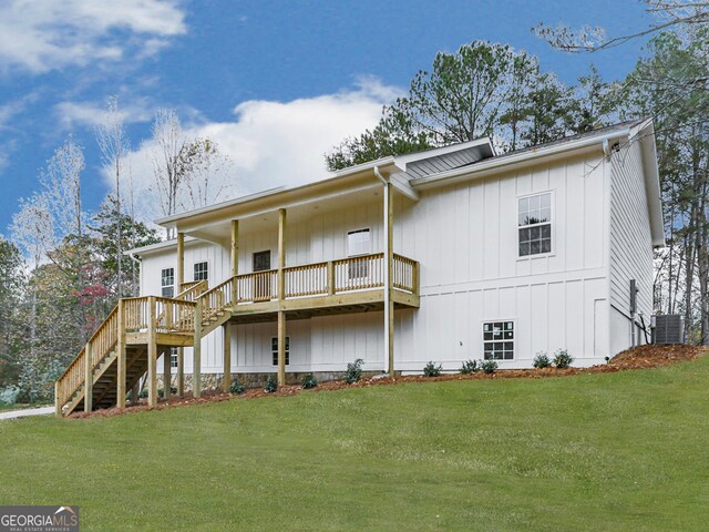 rear view of property featuring central AC unit and a yard