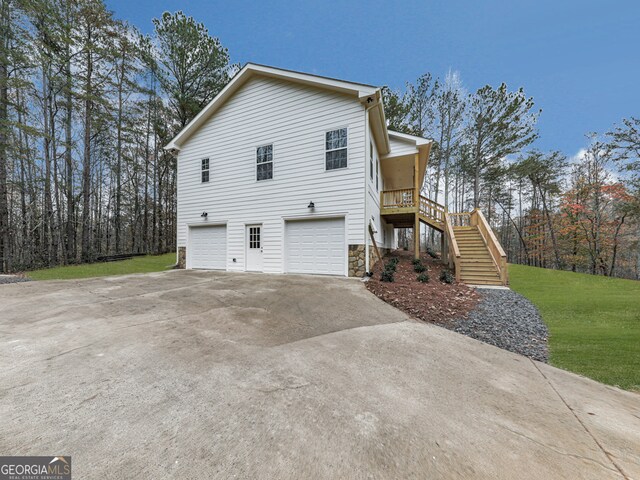 view of property exterior featuring a garage and a lawn