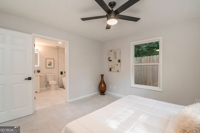 bedroom with carpet flooring, connected bathroom, baseboards, and ceiling fan