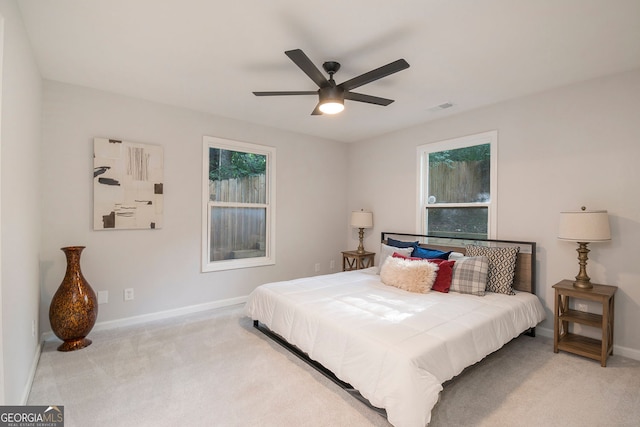 carpeted bedroom featuring a ceiling fan, visible vents, and baseboards