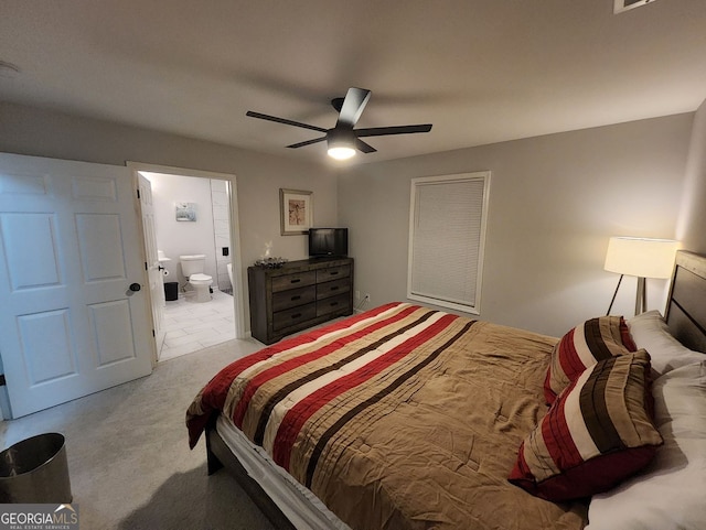 carpeted bedroom featuring a ceiling fan, visible vents, and ensuite bath