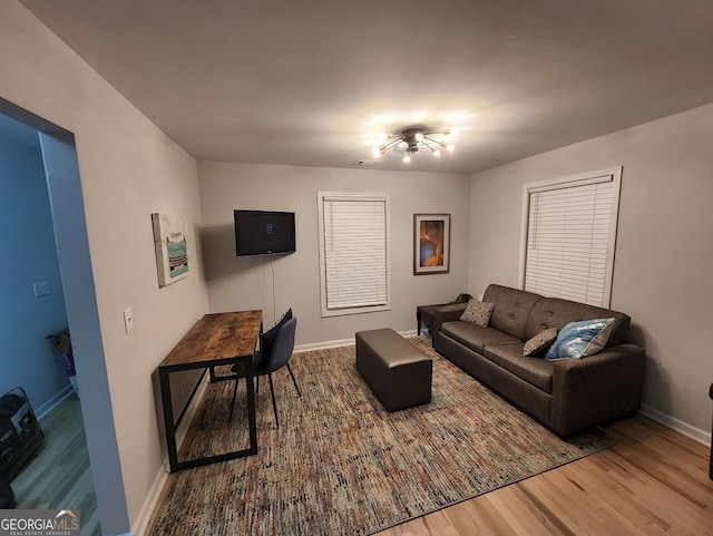 living area with baseboards and wood finished floors