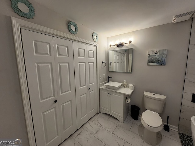 bathroom with toilet, vanity, visible vents, baseboards, and marble finish floor