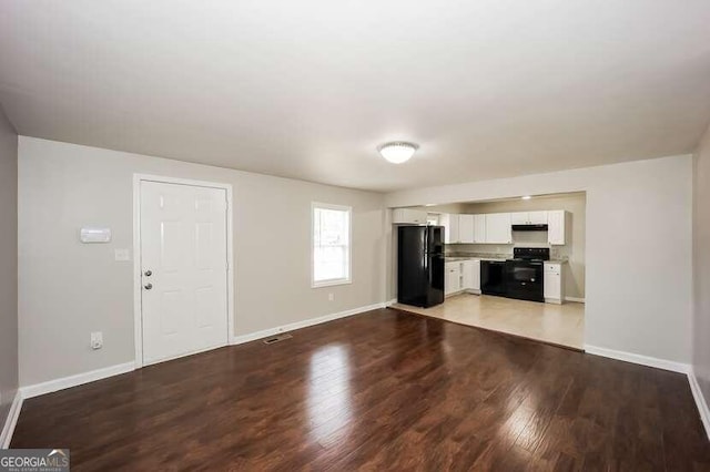 unfurnished living room with wood-type flooring