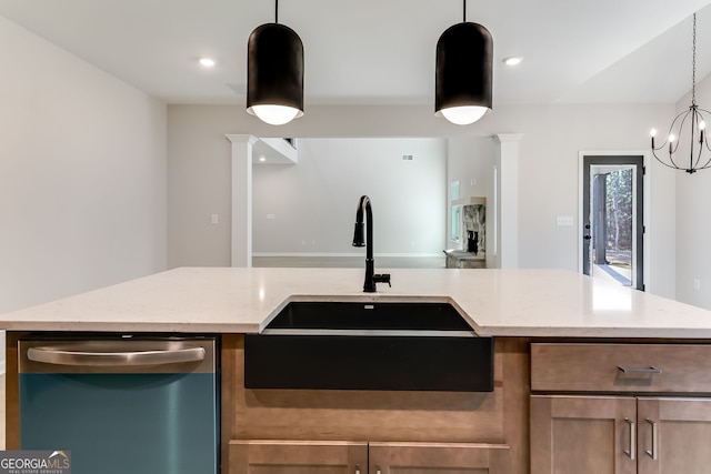 kitchen with light stone countertops, dishwasher, sink, decorative columns, and pendant lighting