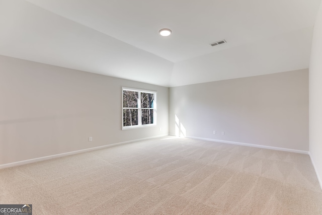 carpeted empty room featuring lofted ceiling