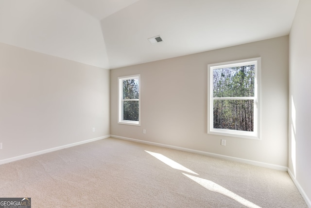 carpeted empty room with lofted ceiling