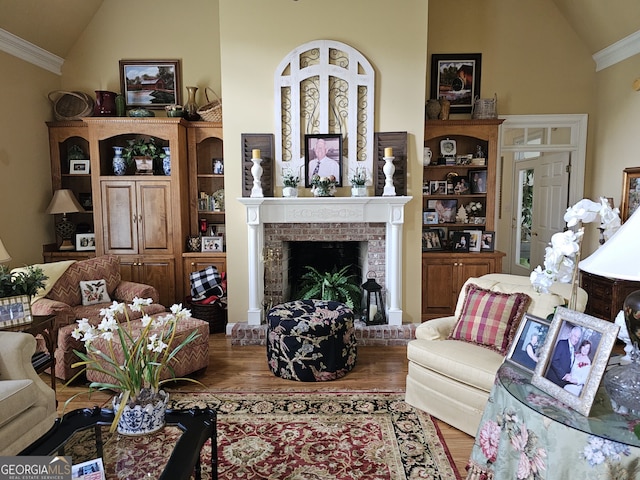 living room with wood-type flooring, crown molding, high vaulted ceiling, and a brick fireplace