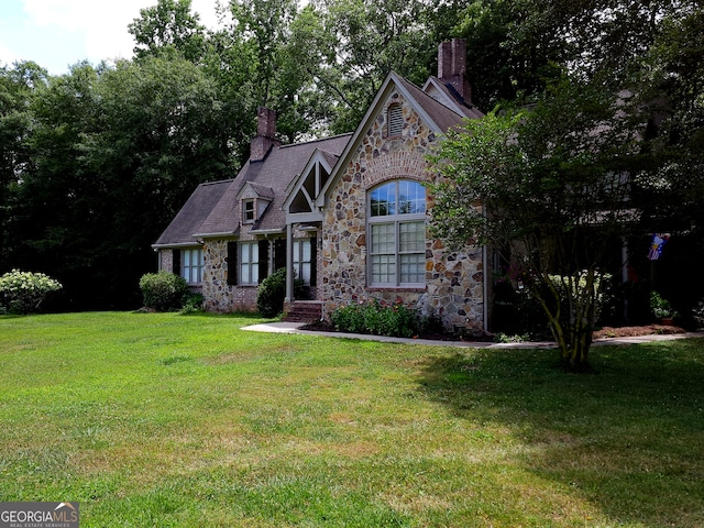 tudor-style house featuring a front yard