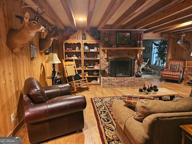 living room with beam ceiling, a fireplace, wood walls, and hardwood / wood-style floors