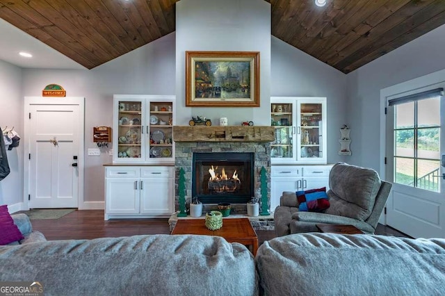 living room featuring wood ceiling, dark hardwood / wood-style floors, high vaulted ceiling, a stone fireplace, and ceiling fan