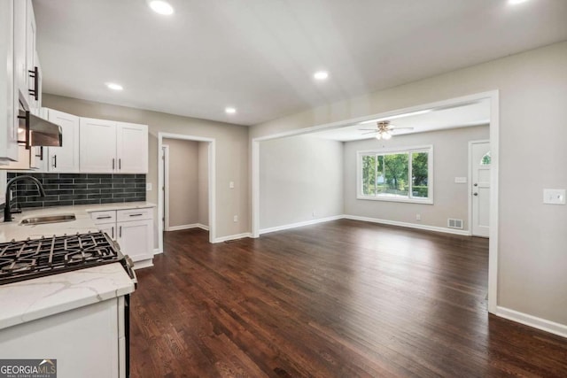 kitchen with light stone countertops, white cabinetry, ceiling fan, and dark hardwood / wood-style floors