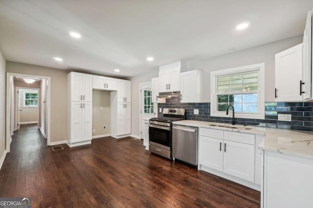 kitchen with white cabinets, appliances with stainless steel finishes, and dark wood-type flooring