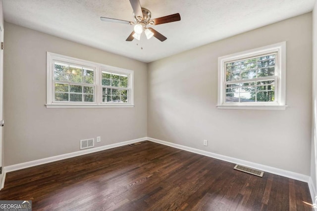 spare room with ceiling fan, a textured ceiling, and dark hardwood / wood-style floors