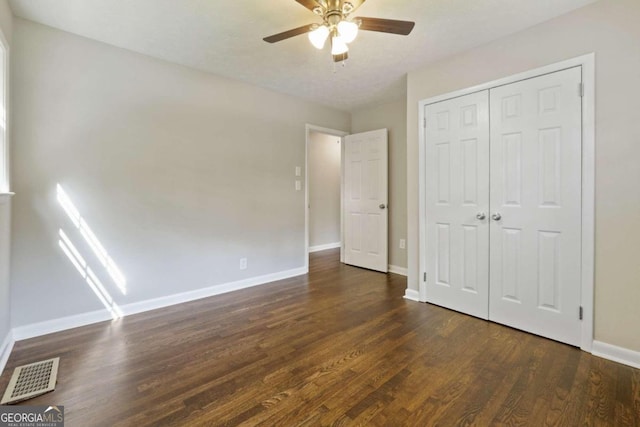 unfurnished bedroom featuring a closet, ceiling fan, dark wood-type flooring, and a textured ceiling