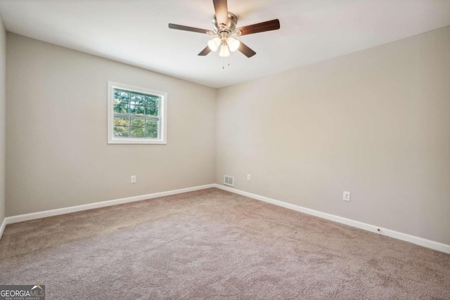 carpeted spare room with ceiling fan