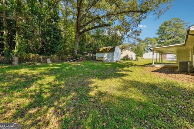 view of yard featuring central AC unit and an outbuilding