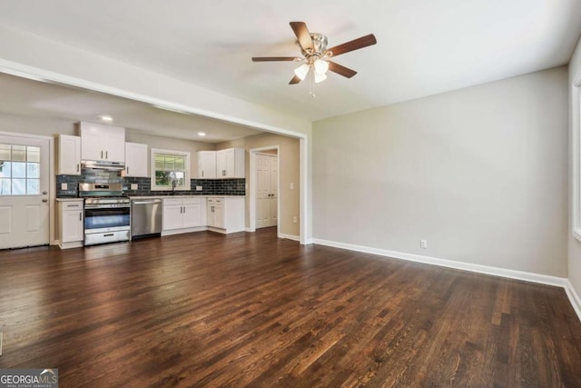 unfurnished living room featuring ceiling fan, plenty of natural light, and dark hardwood / wood-style floors