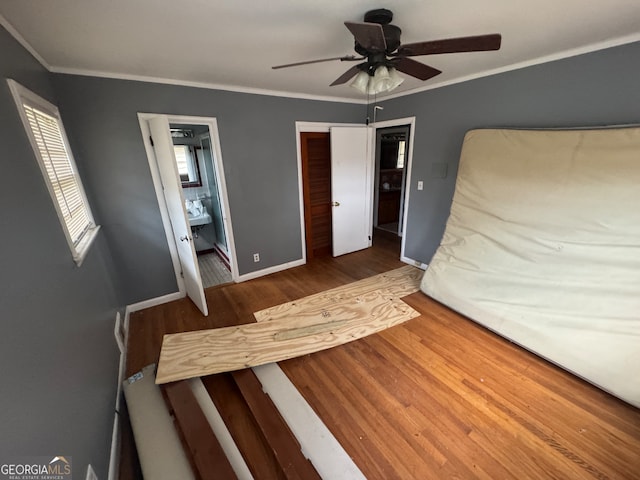 unfurnished bedroom with ceiling fan, ornamental molding, dark wood-type flooring, and ensuite bathroom